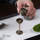 優雅に舞う鶴を頂いた高脚型の香炉。
繊細な透かし彫りとアンティーク調の質感が、和の空間にも洋のインテリアにも自然に溶け込みます。
お香の香りをゆっくりと広げ、日常に穏やかな時間を添える一品。